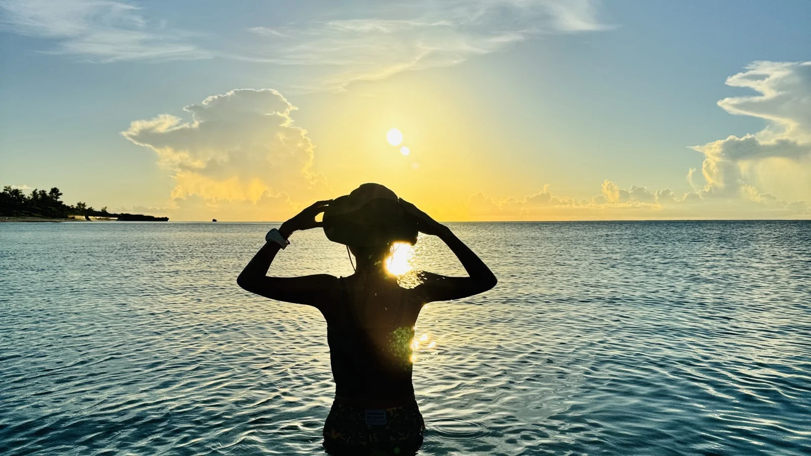 沖縄の夕日と海に立つ人のシルエット